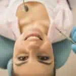 young woman in dental chair looking up