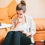 young woman biting nails studying