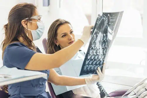 woman and dentist examine x-rays