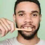 man with gapped teeth brushing teeth